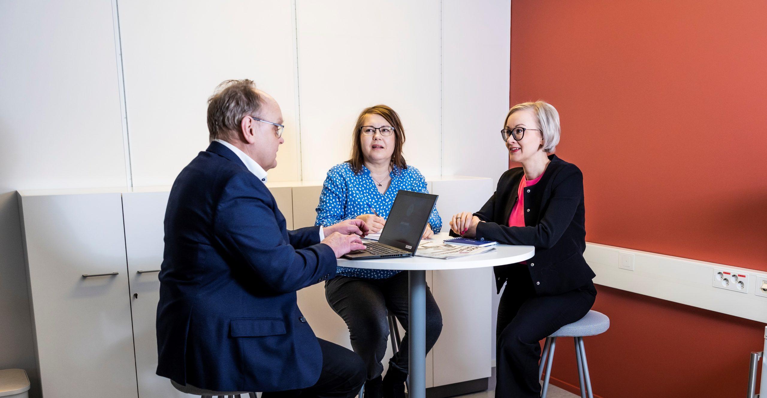 Kuvassa on kolme henkilöä istumassa pöydän ääressä Seinäjoen yliopistokeskuksen tiloissa.